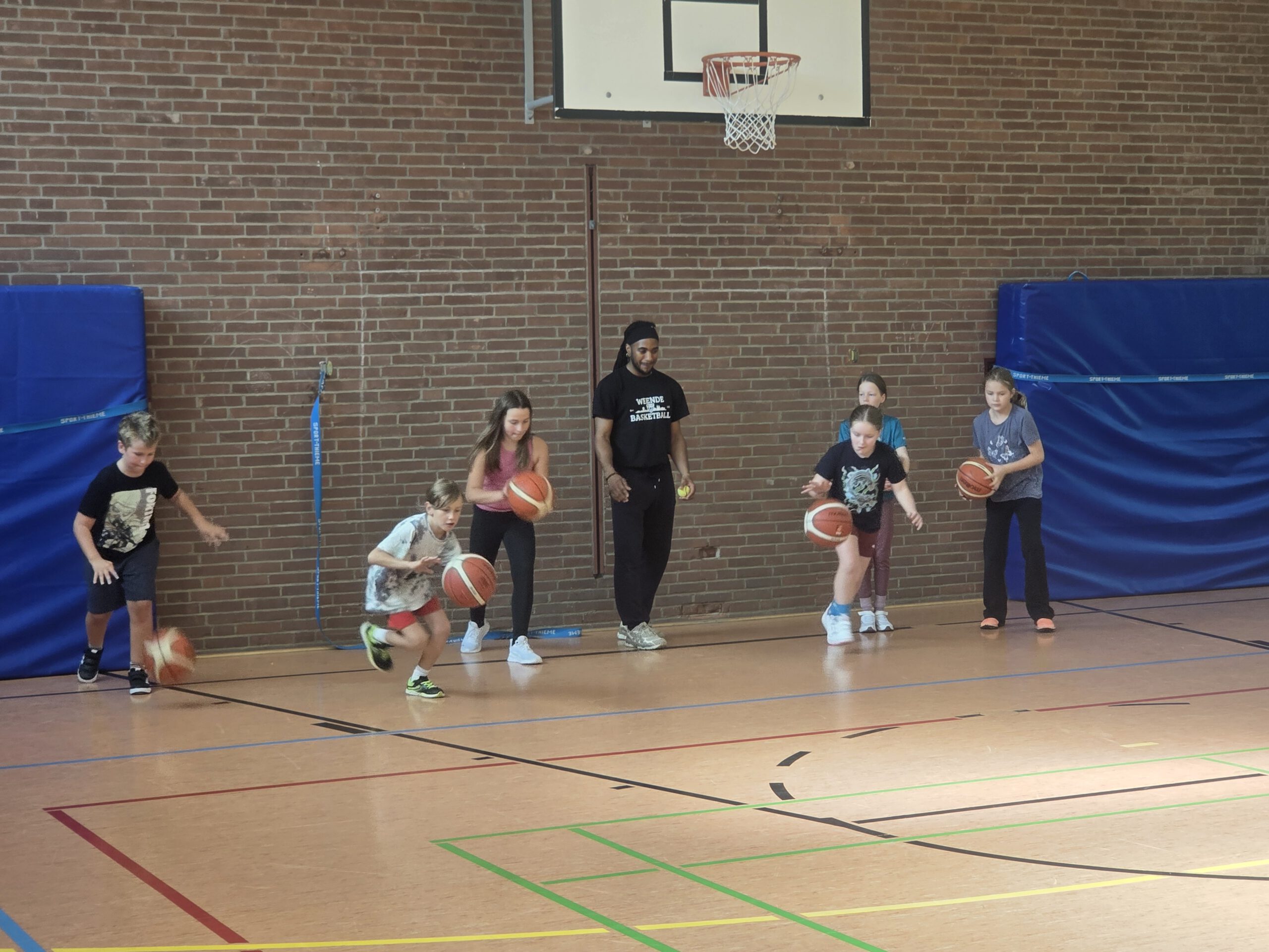 Kinder üben beim Sportaktionstag das Dribbeln mit Basketbällen