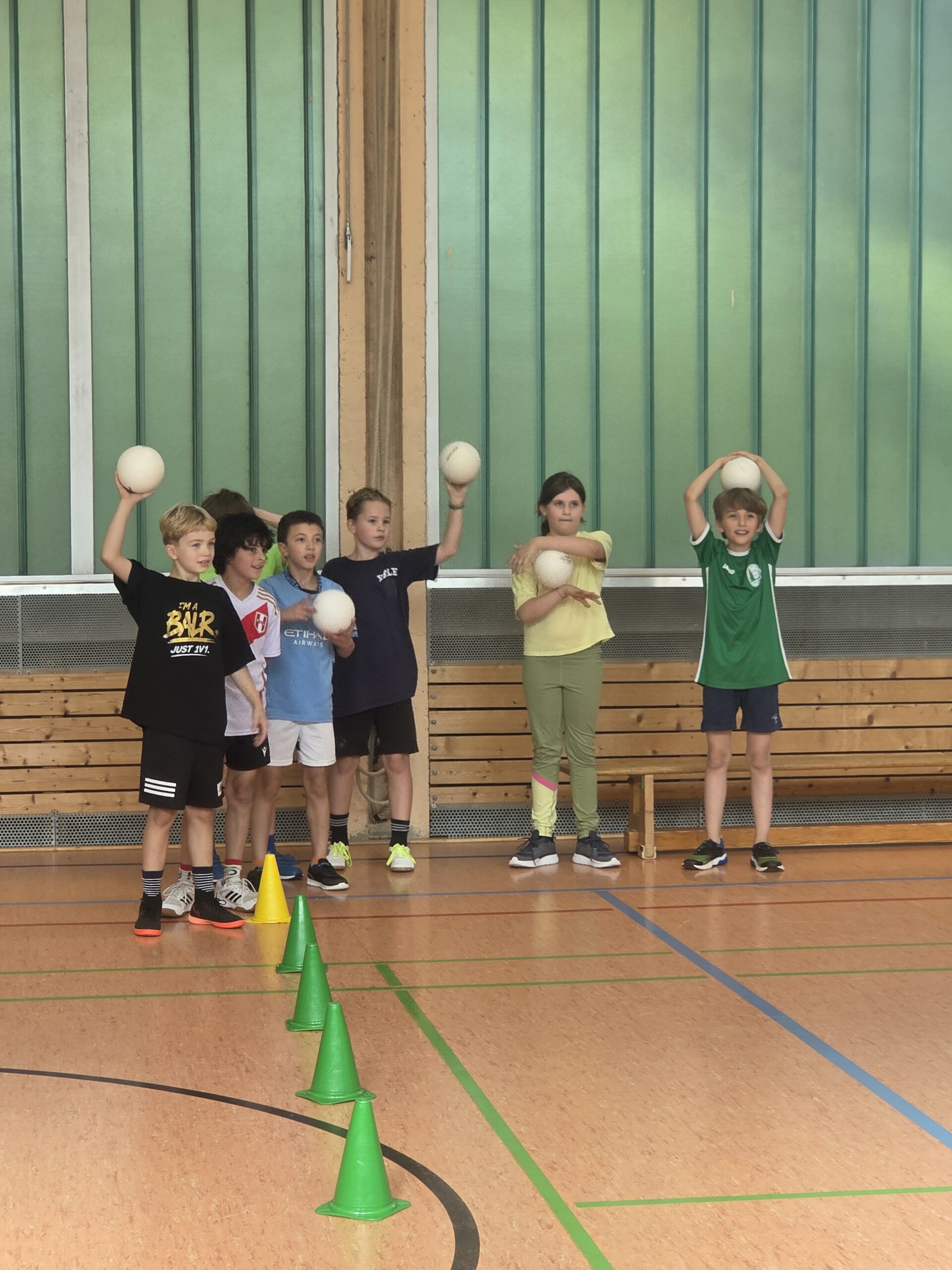 Kinder üben beim Sportaktionstag das Werfen mit Handbällen